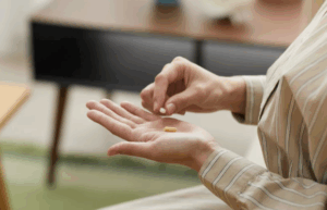 Person taking supplement pills in hand