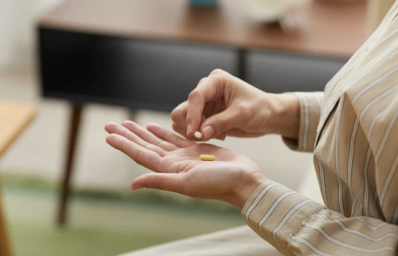 women taking supplement pill