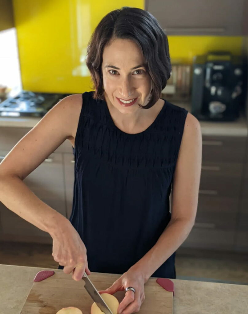 Dr. Annie chopping vegetables in kitchen.