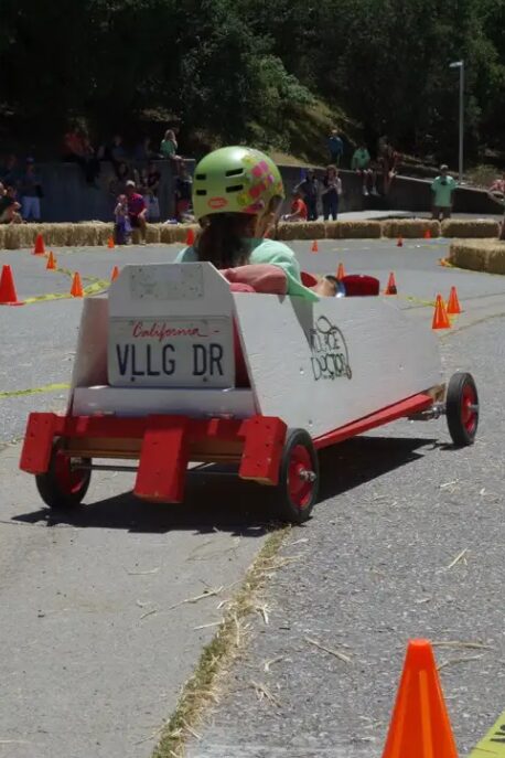 Child racing a homemade soapbox car