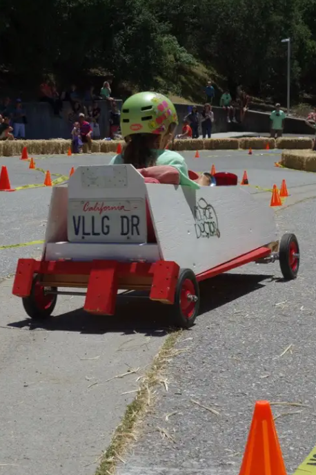 Child racing a homemade soapbox car