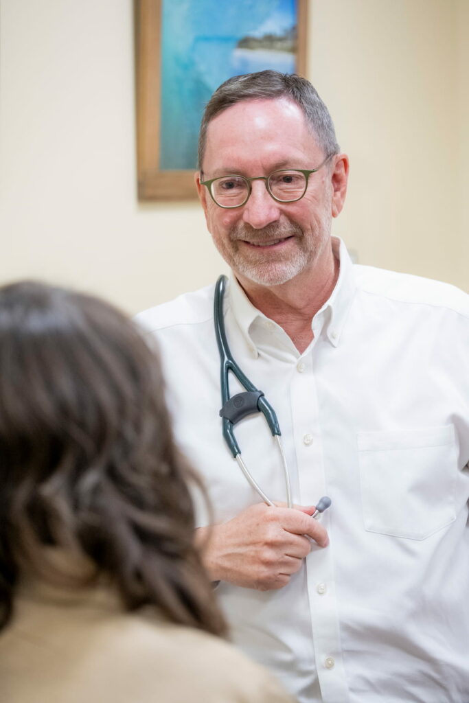 Doctor Eric smiling while talking to patient