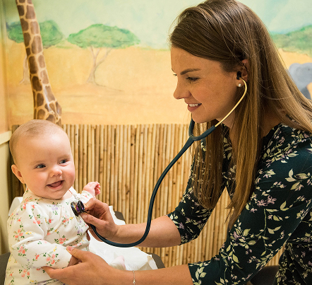 Dr. Jacqueline Phillips checking baby's heartbeat happily.